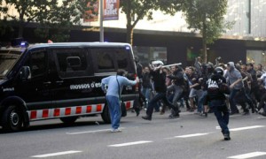Barcelona, Spain, 29 March 2012: Workers and their supporters attack a police van during a general strike by Spanish workers against reforms making it easier for bosses to slash jobs, wages and conditions.