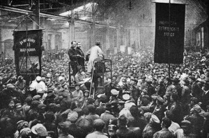  Russia, 1917: Mass political meeting of workers at the giant Putilov factory. This factory which produced railway vehicles as well as artillery and other metal products was a stronghold of the Bolsheviks. Banners and speakers proclaimed the unity of the toilers of all races and peoples.