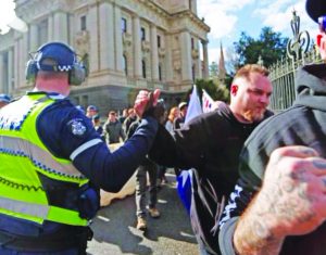 Showing which side they are on! A policeman publicly high-fives a member of the fascist United Patriots Front during their 18 July 2015 race-hate rally in Melbourne. As a core part of the capitalist state, the police in this current system cannot be allies in the anti-fascist struggle but are, instead, a major force impeding the fight against fascism.